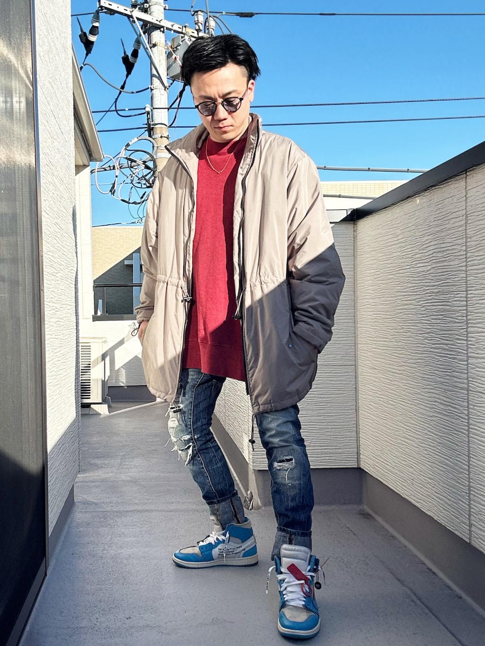 レッド系のスウェット、ベージュ系のその他アウター、ブルー系のデニムパンツを着用したメンズの冬コーディネートの2枚目の写真