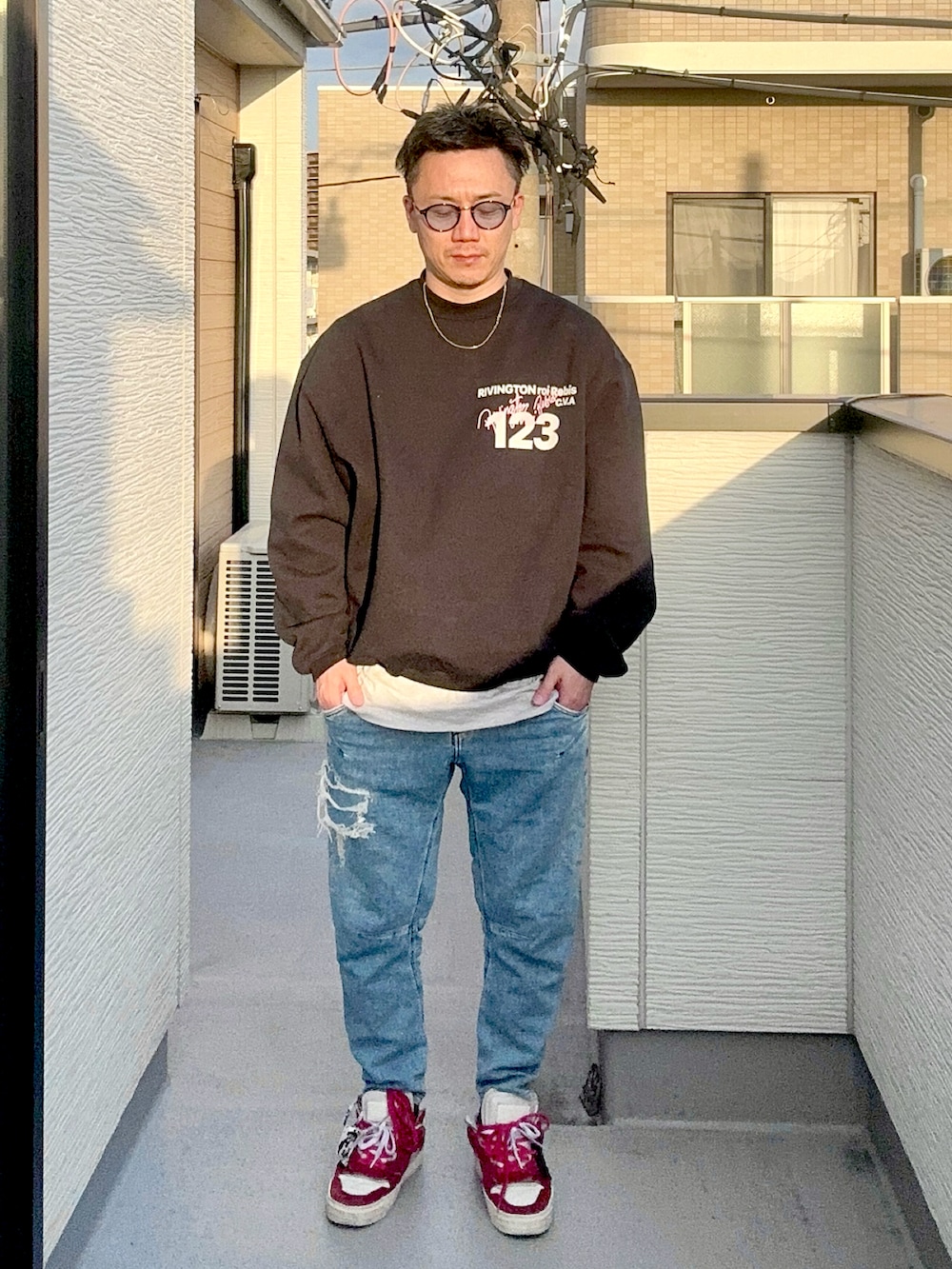 グレー系のTシャツ/カットソー、ブルー系のデニムパンツ、ブラック系のスウェットを着用したメンズの秋コーディネートの3枚目の写真