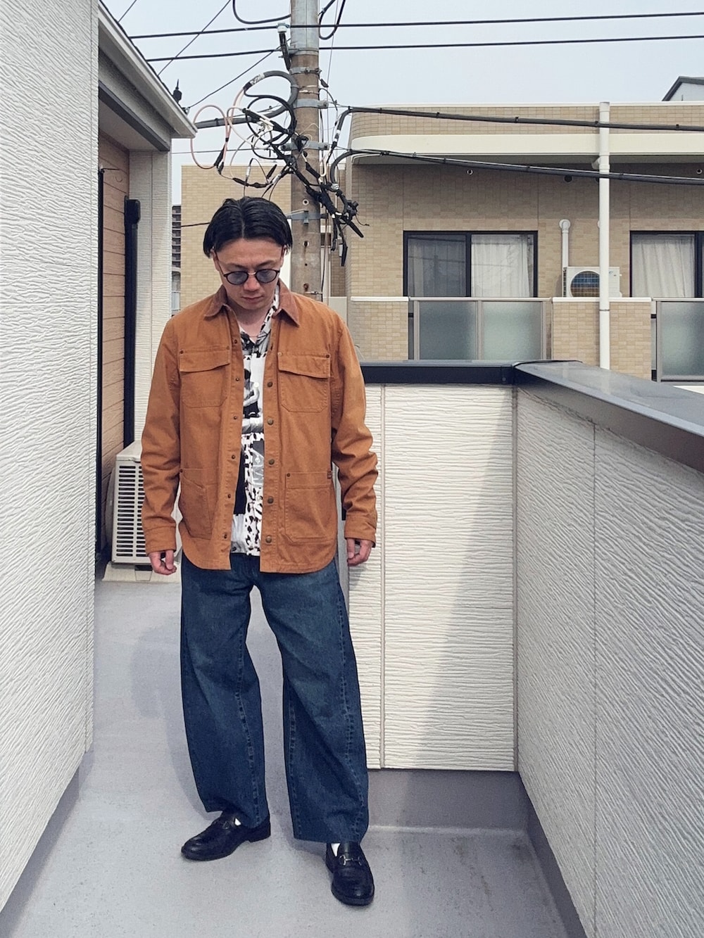 ブラック系のローファー、ホワイト系のシャツ/ブラウス、ブラウン系のカバーオールを着用したメンズの春コーディネートの3枚目の写真