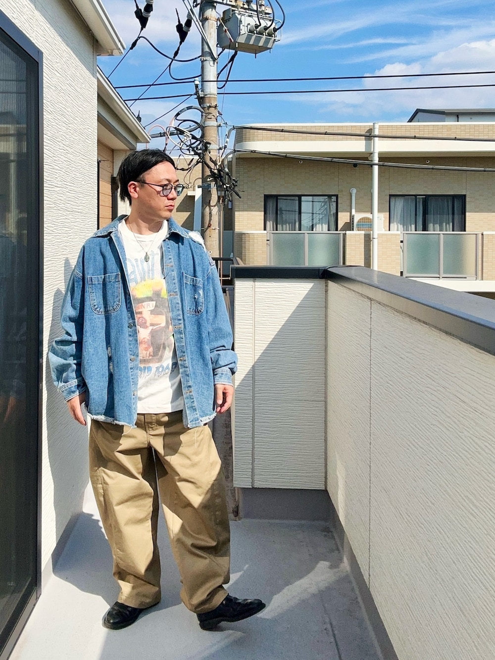 ホワイト系のTシャツ/カットソー、ブルー系のデニムジャケット、ベージュ系のパンツを着用したメンズの秋コーディネートの2枚目の写真