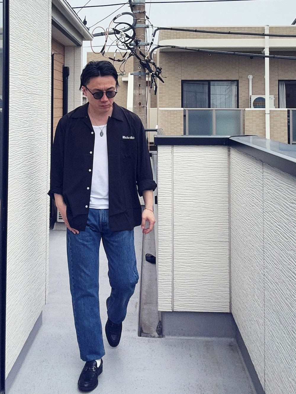 ブルー系のデニムパンツ、ブラック系のローファー、ホワイト系のタンクトップを着用したメンズの春コーディネートの2枚目の写真