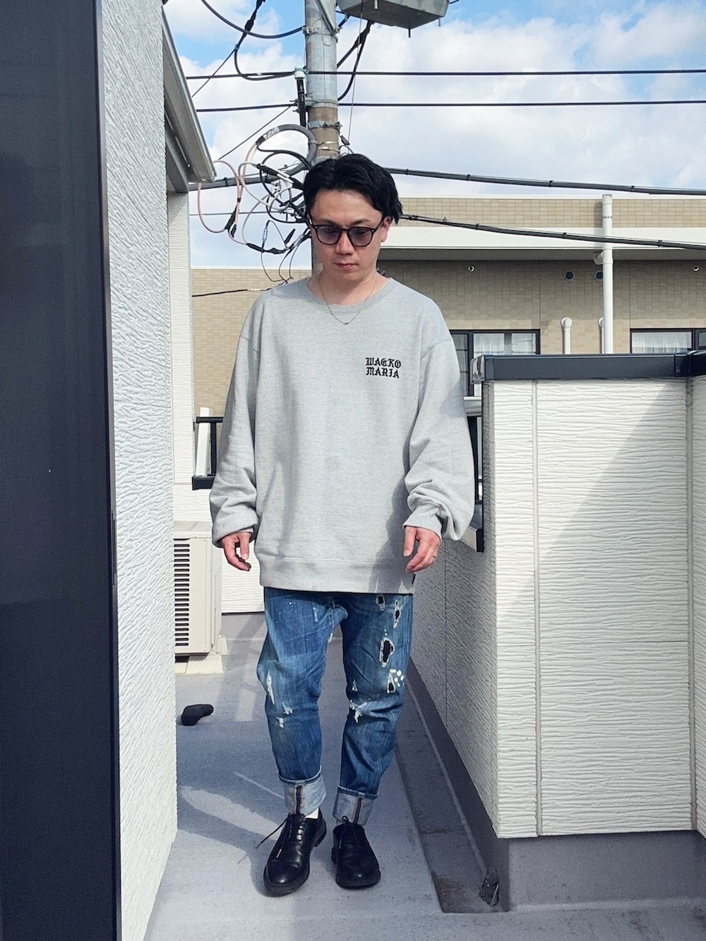 ブルー系のデニムパンツ、グレー系のスウェット、ブラック系のドレスシューズを着用したメンズの冬コーディネートの2枚目の写真