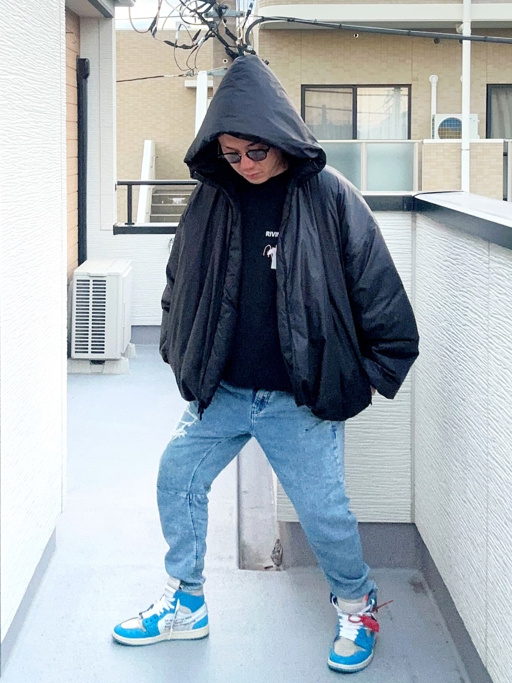 ブルー系のデニムパンツ、ブラック系のスウェット、ブラック系のジャケット/アウターを着用したメンズの冬コーディネートの3枚目の写真