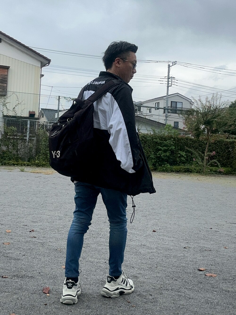 ブルー系のデニムパンツ、グレー系のTシャツ/カットソー、ブラック系のバックパック/リュックを着用したメンズの秋コーディネートの5枚目の写真