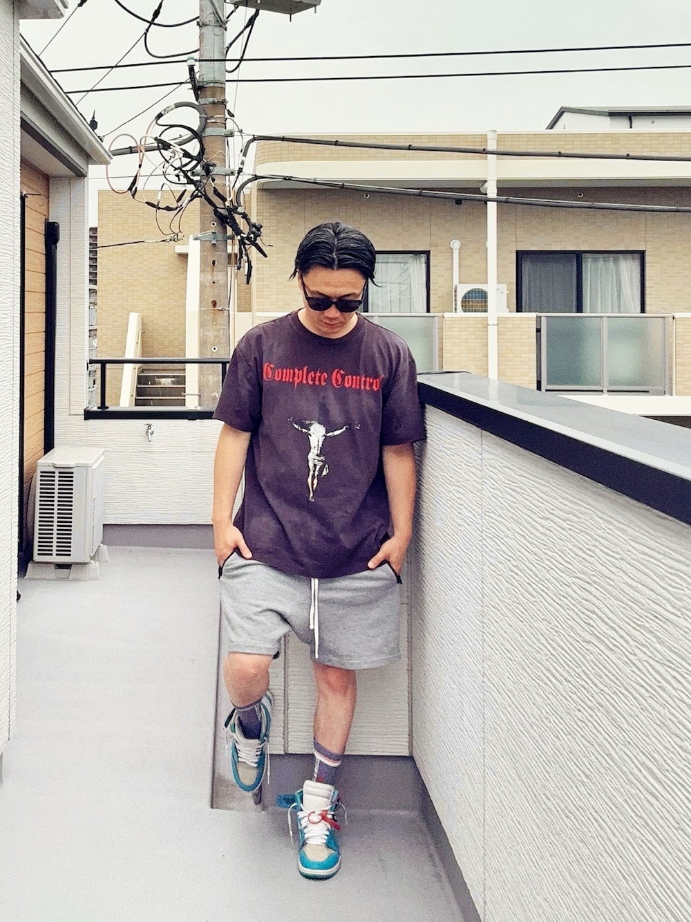 ブラック系のTシャツ/カットソー、グレー系のパンツ、ブルー系のスニーカーを着用したメンズの夏コーディネートの2枚目の写真