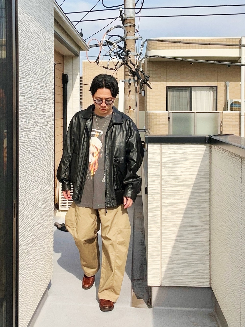 ブラック系のブルゾン、ブラック系のTシャツ/カットソー、ベージュ系のパンツを着用したメンズの秋コーディネートの2枚目の写真