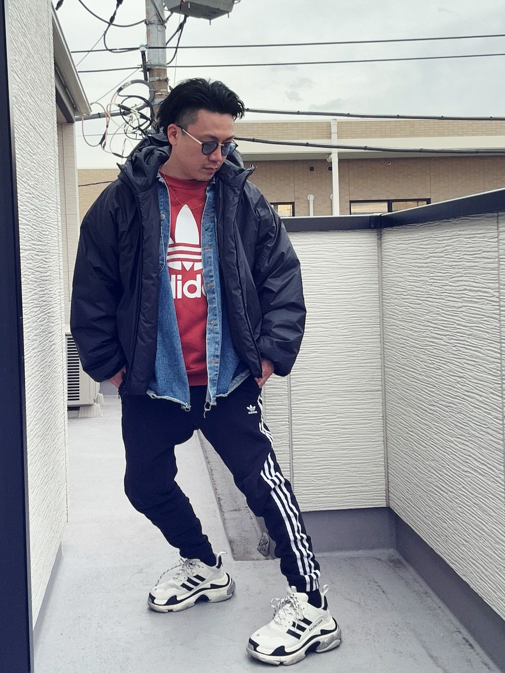 オレンジ系のスウェット、ブラック系のスウェットパンツ、ブラック系のジャケット/アウターを着用したメンズの冬コーディネートの2枚目の写真