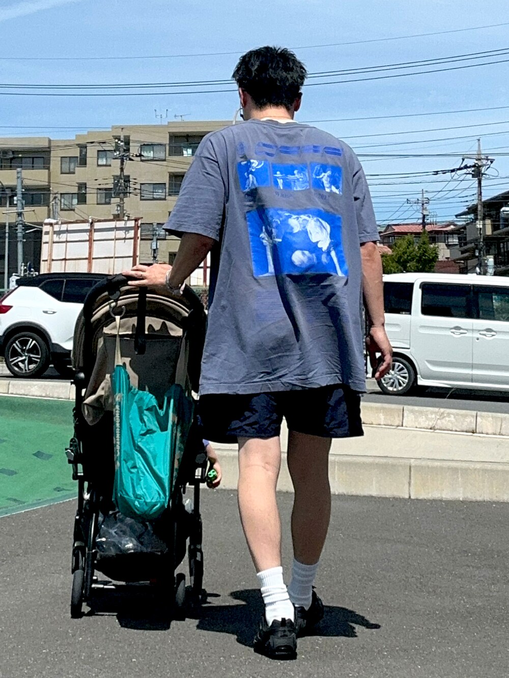 ブラック系のスニーカー、ブルー系のTシャツ/カットソー、ブルー系のパンツを着用したメンズの夏コーディネートの3枚目の写真