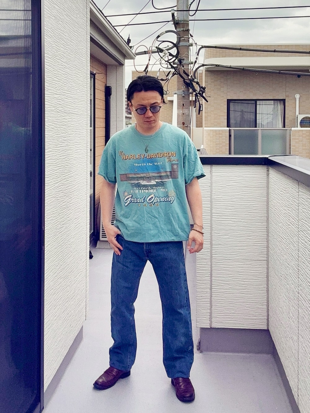 ブルー系のデニムパンツ、ブルー系のTシャツ/カットソー、ブラウン系のローファーを着用したメンズの春コーディネートの3枚目の写真