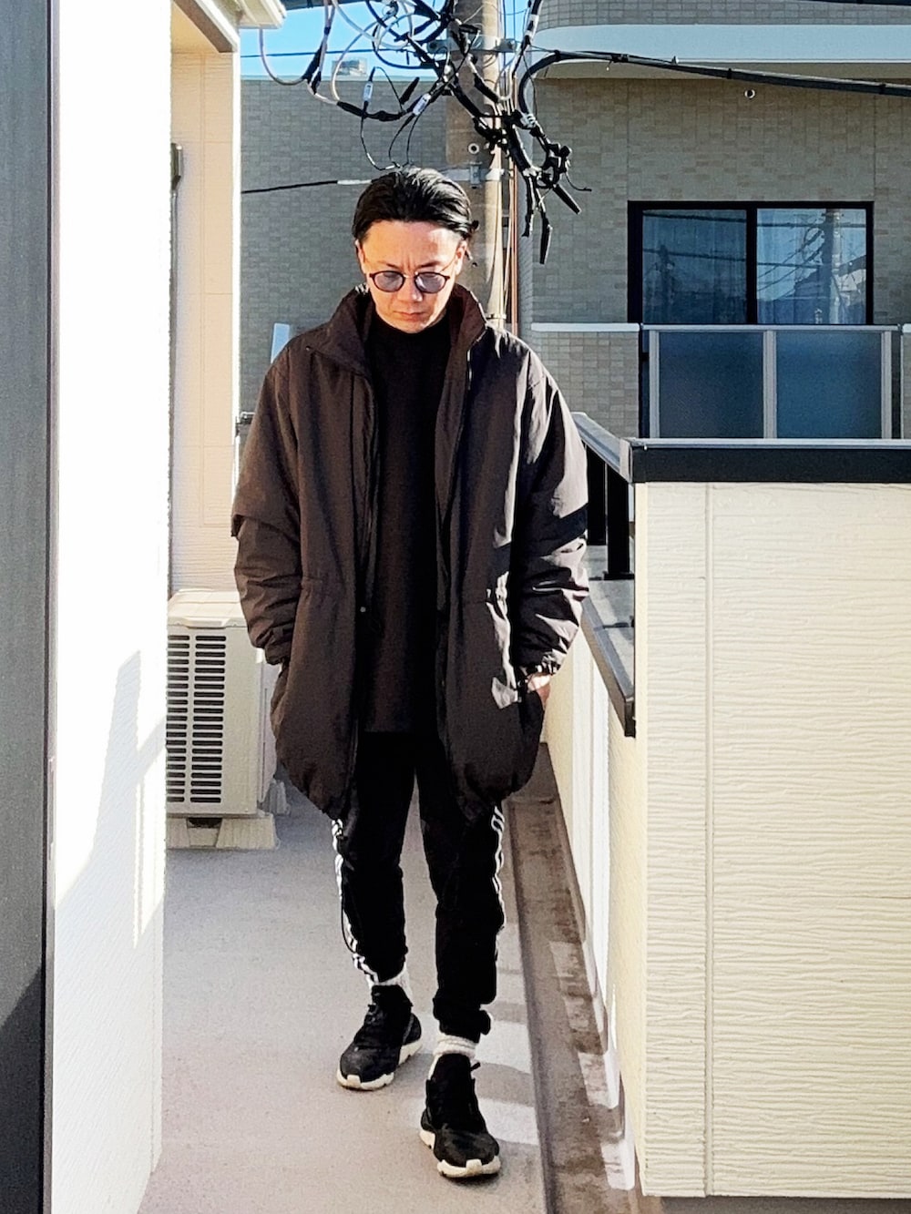 ブラック系のスウェット、ブラック系のスウェットパンツ、ブラック系のスニーカーを着用したメンズの冬コーディネートの5枚目の写真