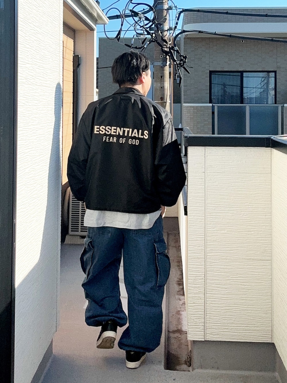 グレー系のTシャツ/カットソー、ブラック系のナイロンジャケット、ブルー系のカーゴパンツを着用したメンズの秋コーディネートの3枚目の写真