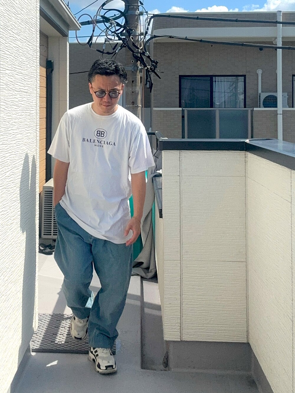 ホワイト系のTシャツ/カットソー、ブルー系のデニムパンツ、ホワイト系のシューズを着用したメンズの秋コーディネートの2枚目の写真