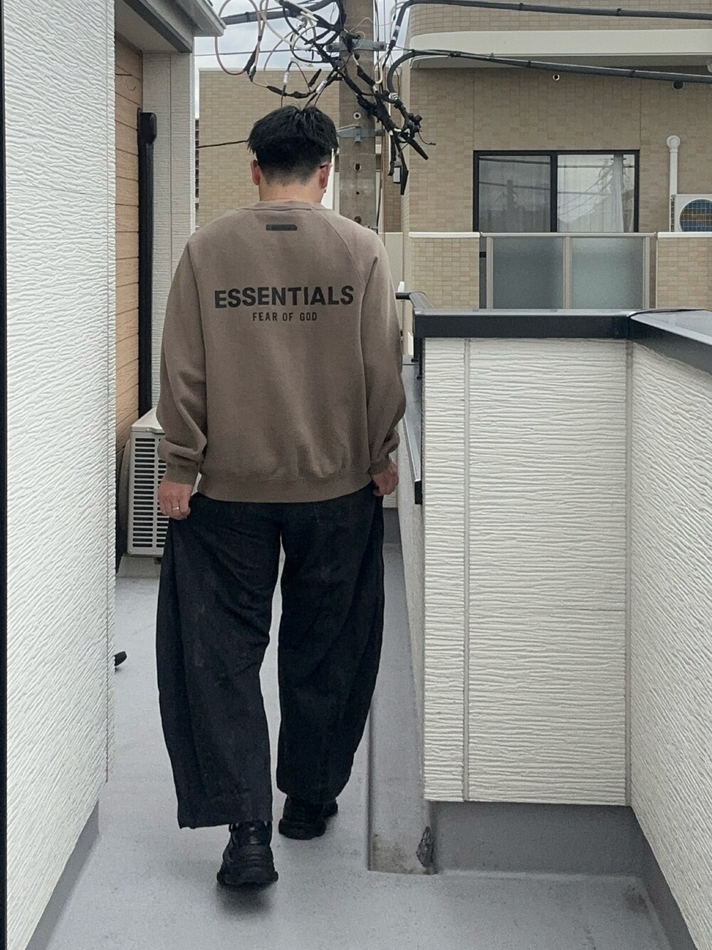 ベージュ系のスウェット、ブラック系のデニムパンツ、ブラック系のシューズを着用したメンズの秋コーディネートの2枚目の写真