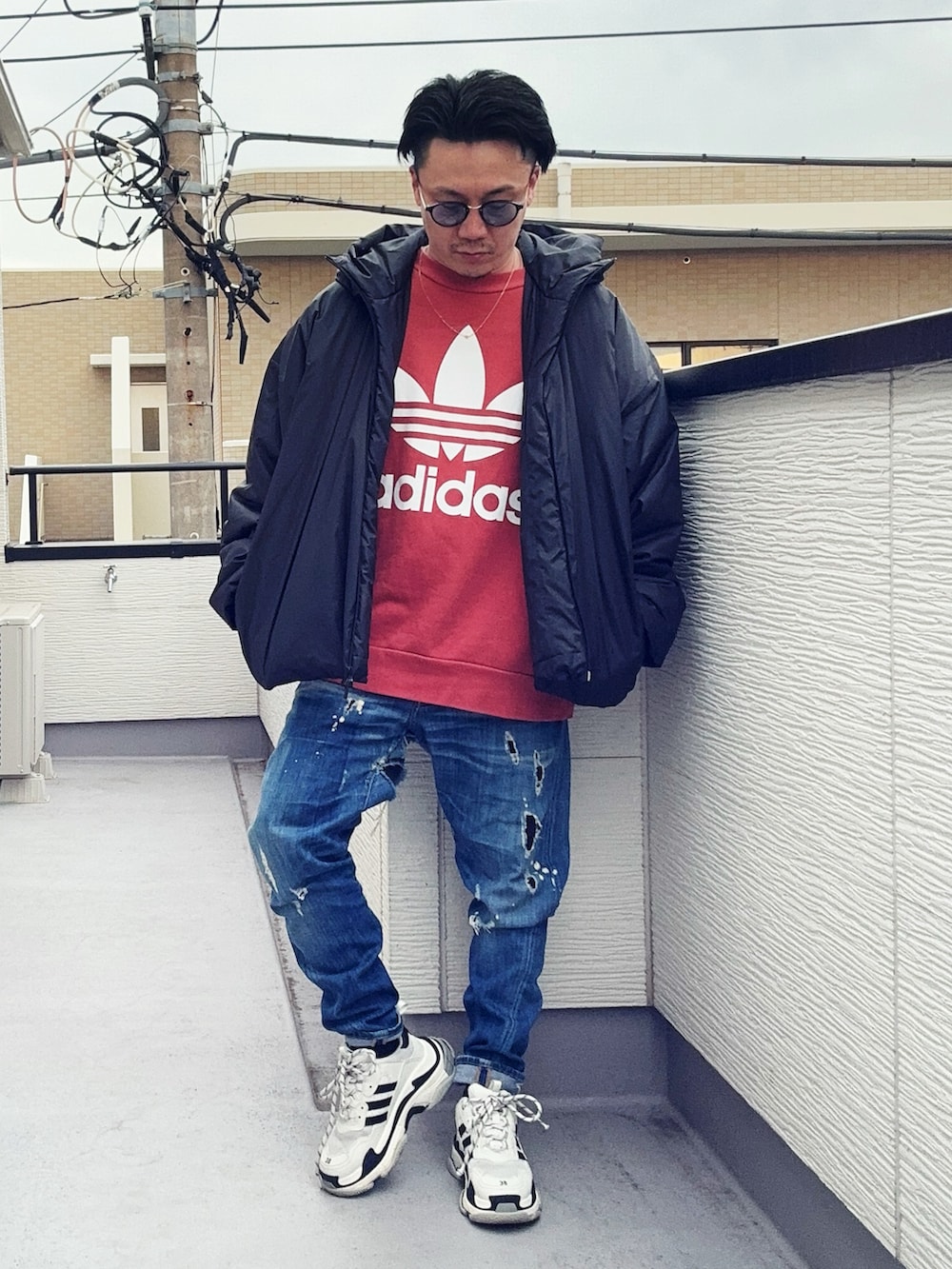 オレンジ系のスウェット、ブルー系のデニムパンツ、ブラック系のジャケット/アウターを着用したメンズの冬コーディネートの2枚目の写真