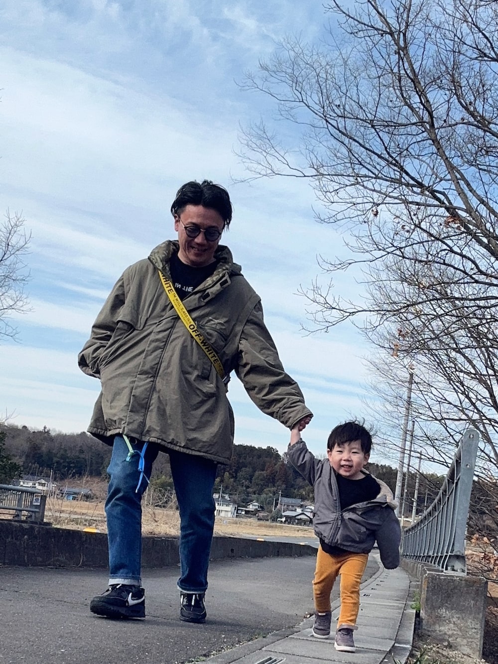 ブラック系のTシャツ/カットソー、ブルー系のデニムパンツ、ブラック系のショルダーバッグを着用したメンズの春コーディネートの2枚目の写真