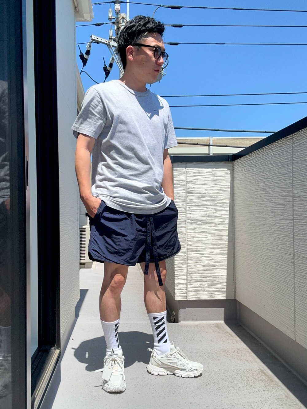 グレー系のTシャツ/カットソー、ブルー系のパンツ、ホワイト系のスニーカーを着用したメンズの夏コーディネートの2枚目の写真