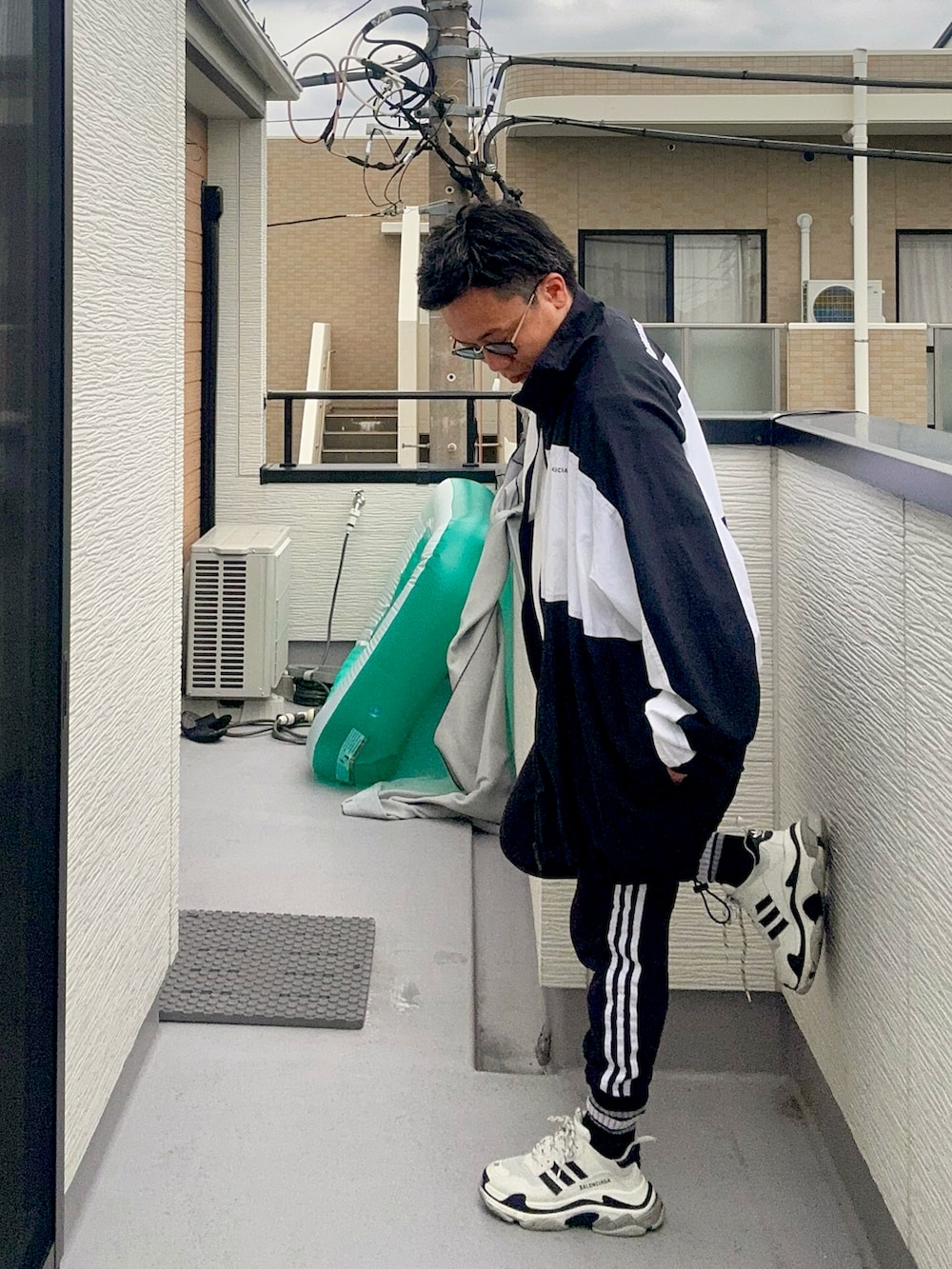 ブラック系のスウェットパンツ、ホワイト系のTシャツ/カットソー、ブラック系のナイロンジャケットを着用したメンズの秋コーディネートの2枚目の写真