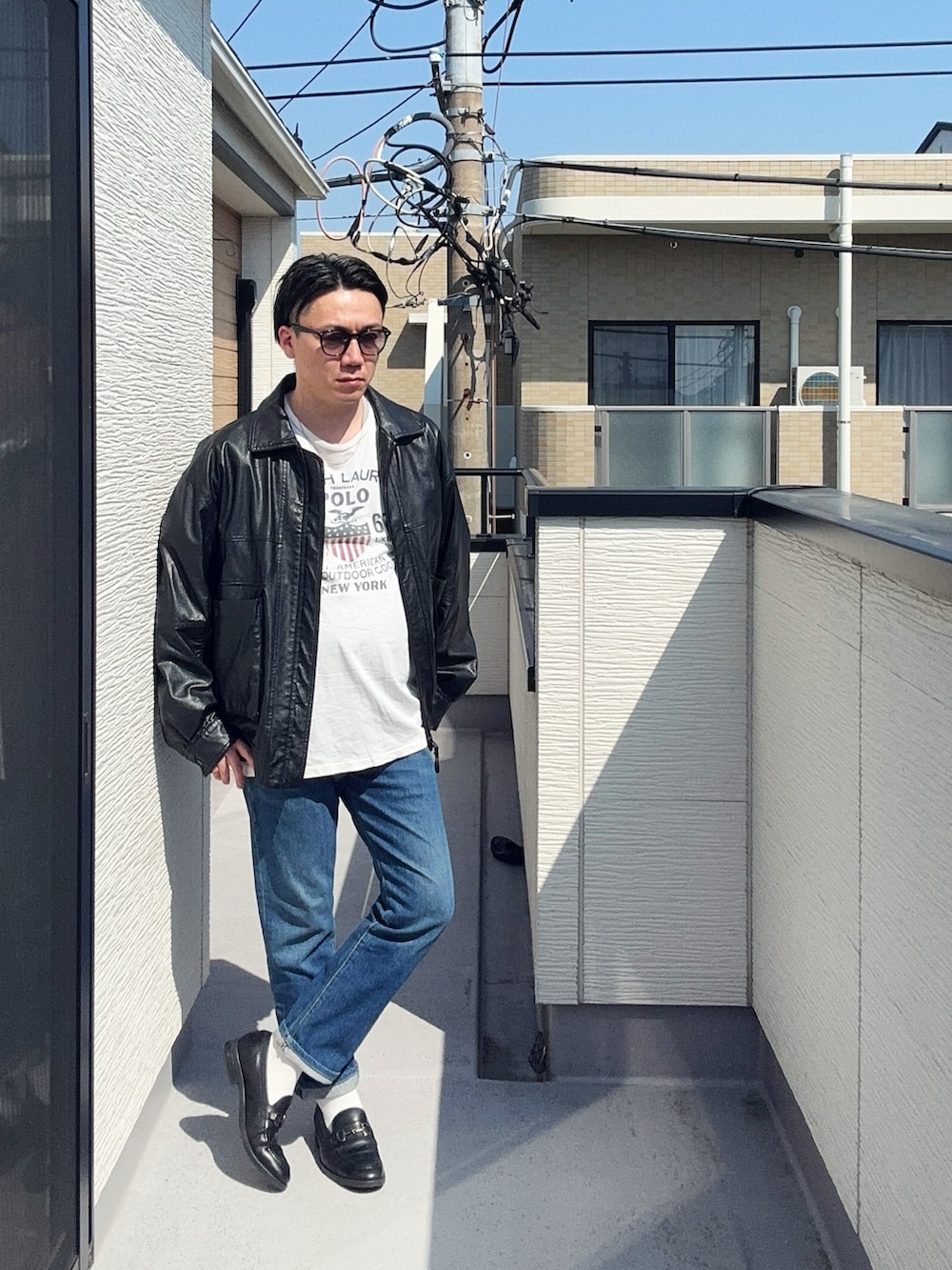 ブラック系のブルゾン、ブルー系のデニムパンツ、ブラック系のローファーを着用したメンズの春コーディネートの2枚目の写真