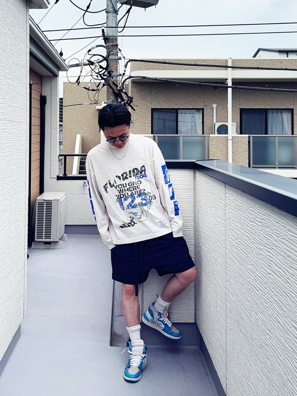 ホワイト系のTシャツ/カットソー、ブルー系のパンツ、ブルー系のスニーカーを着用したメンズの夏コーディネートの2枚目の写真