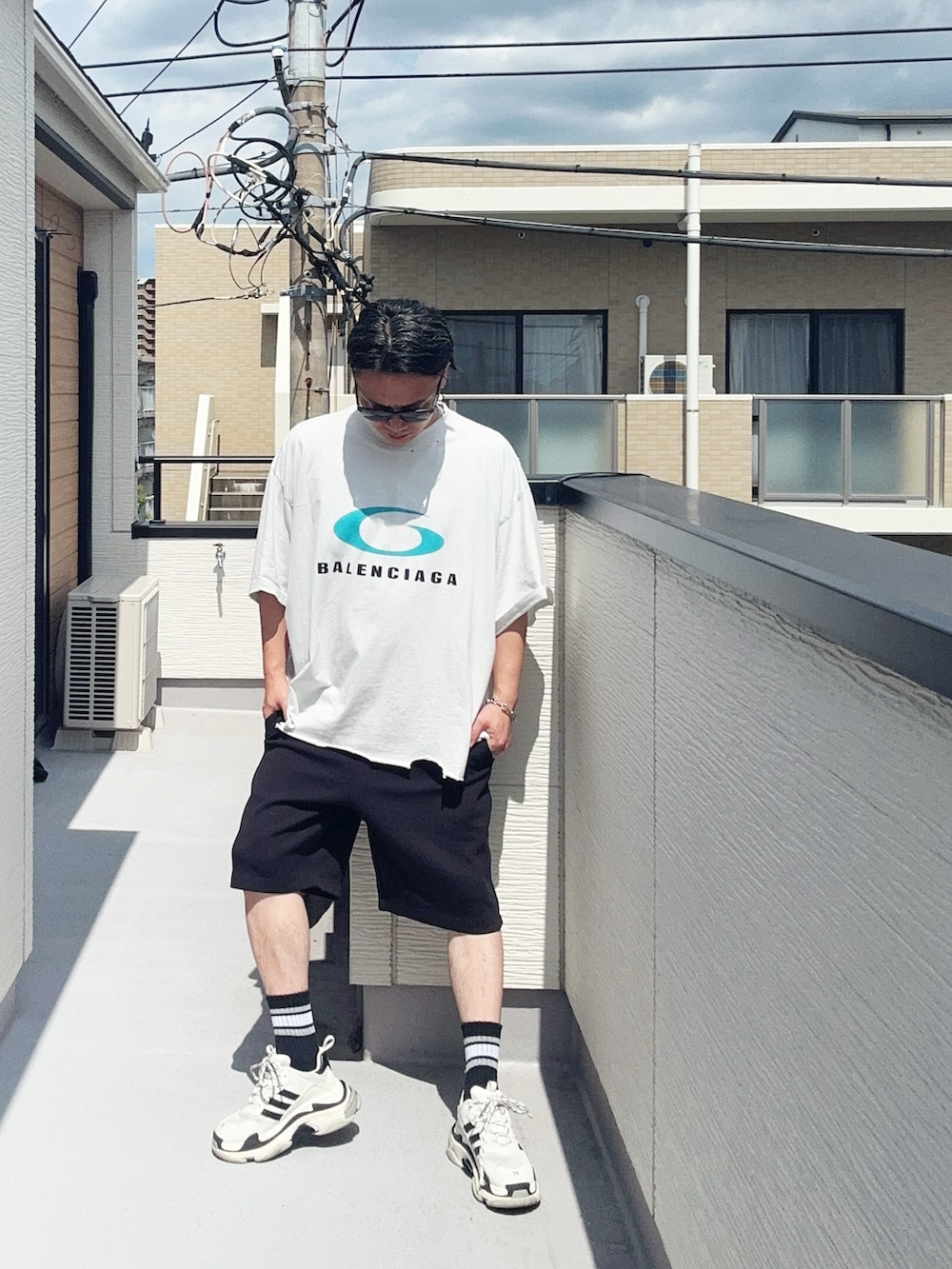 ホワイト系のTシャツ/カットソー、ブラック系のスウェットパンツ、ホワイト系のシューズを着用したメンズの夏コーディネートの2枚目の写真