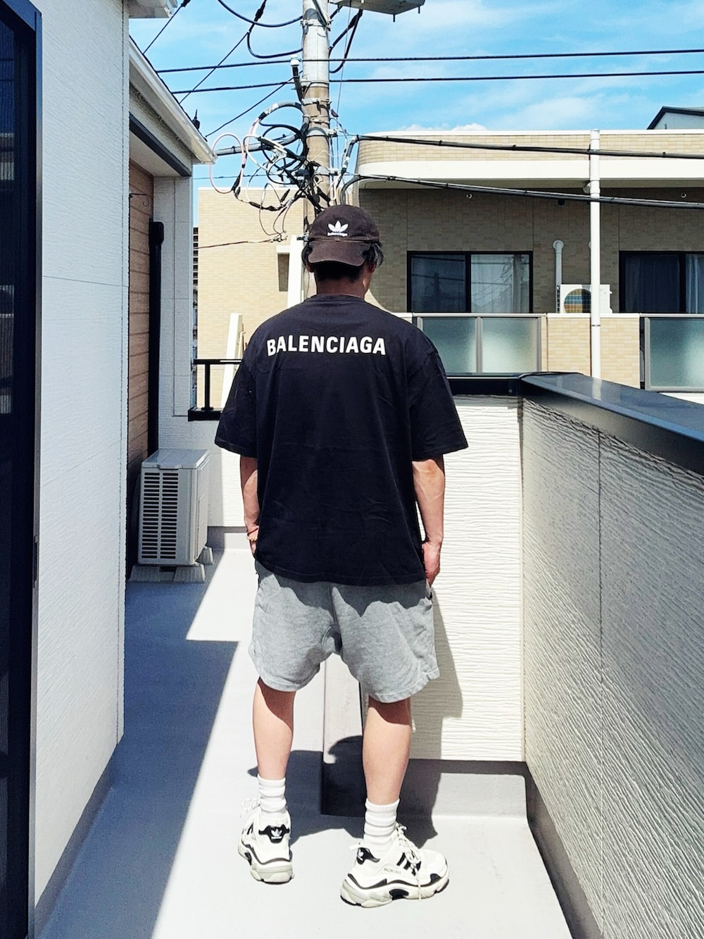 ブラック系のTシャツ/カットソー、グレー系のパンツ、ホワイト系のシューズを着用したメンズの夏コーディネートの3枚目の写真