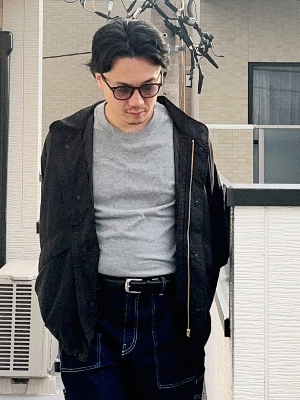 グレー系のTシャツ/カットソー、ブラック系のブルゾン、ブルー系のデニムパンツを着用したメンズの秋コーディネートの3枚目の写真