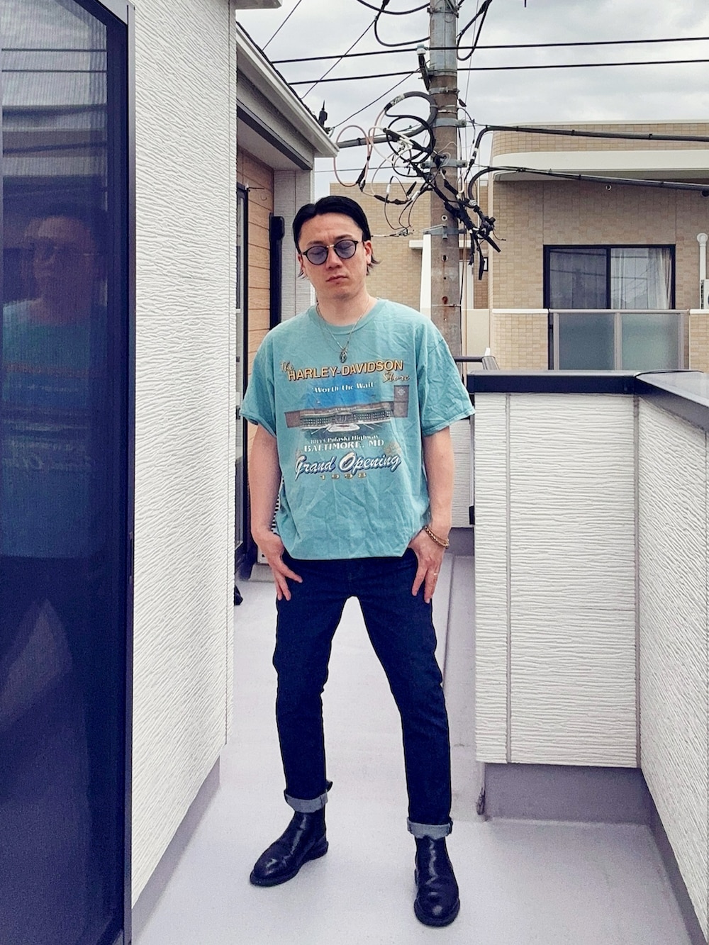 ブルー系のTシャツ/カットソー、ブルー系のデニムパンツ、ブラック系のブーツを着用したメンズの夏コーディネートの2枚目の写真