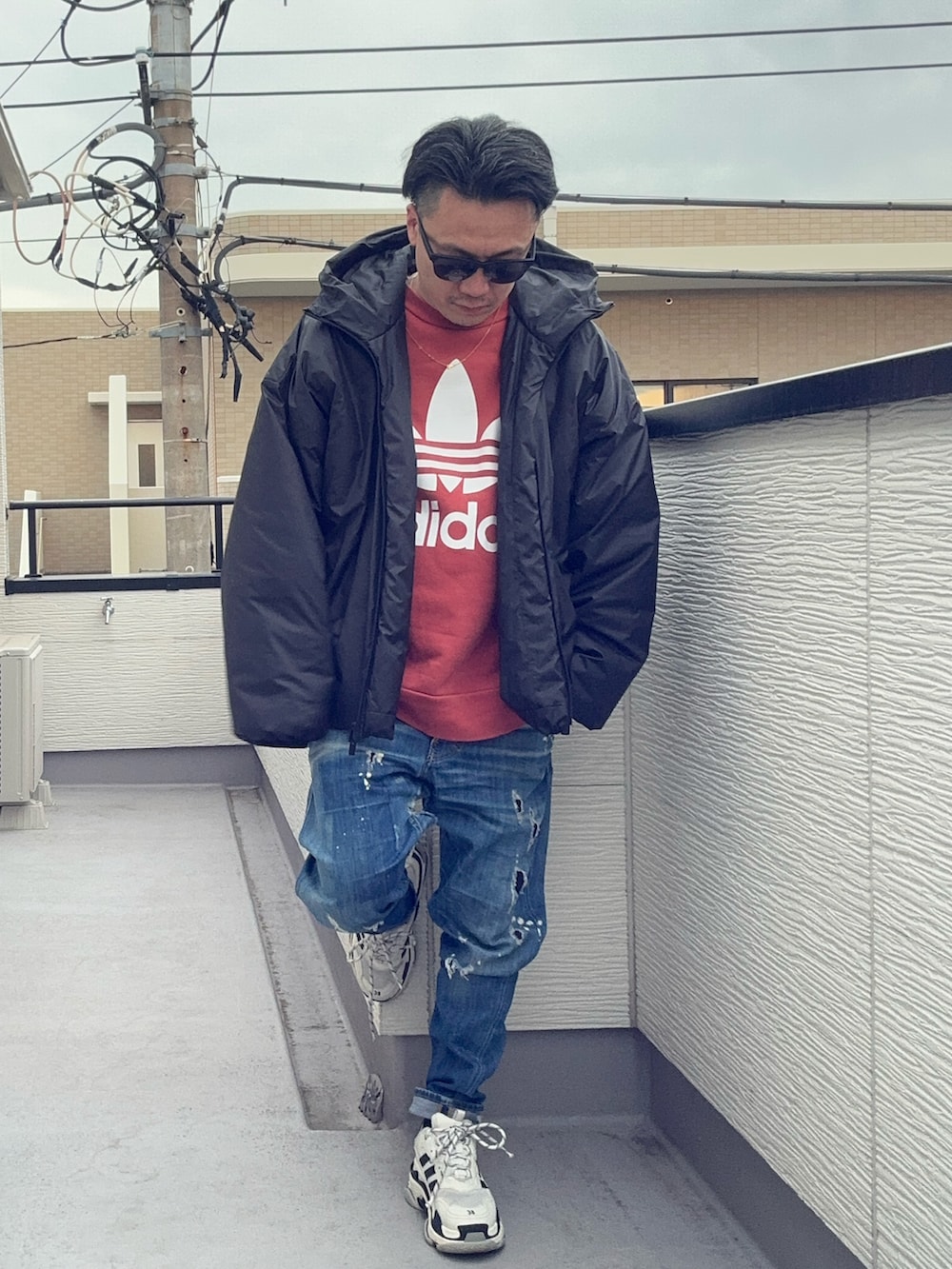 オレンジ系のスウェット、ブルー系のデニムパンツ、ブラック系のジャケット/アウターを着用したメンズの冬コーディネートの4枚目の写真