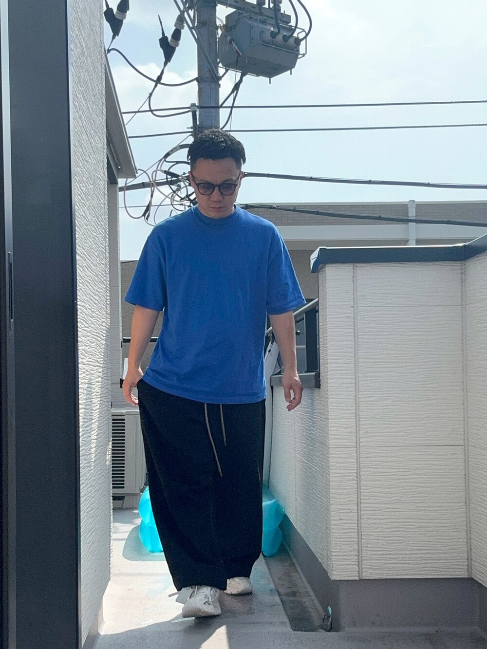 ブラック系のスウェットパンツ、ブルー系のTシャツ/カットソー、ホワイト系のスニーカーを着用したメンズの夏コーディネートの3枚目の写真