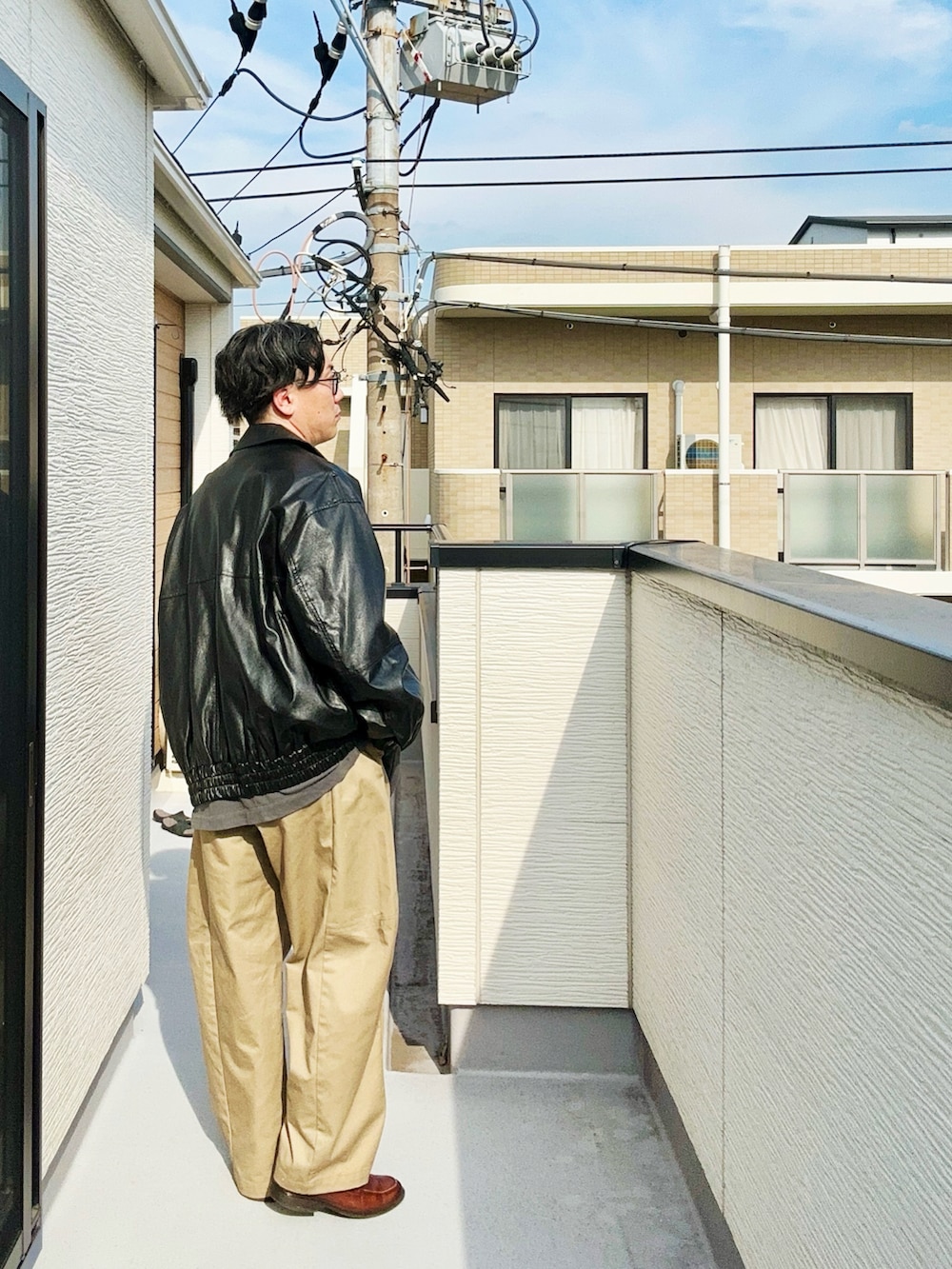 ブラック系のブルゾン、ブラック系のTシャツ/カットソー、ベージュ系のパンツを着用したメンズの秋コーディネートの3枚目の写真