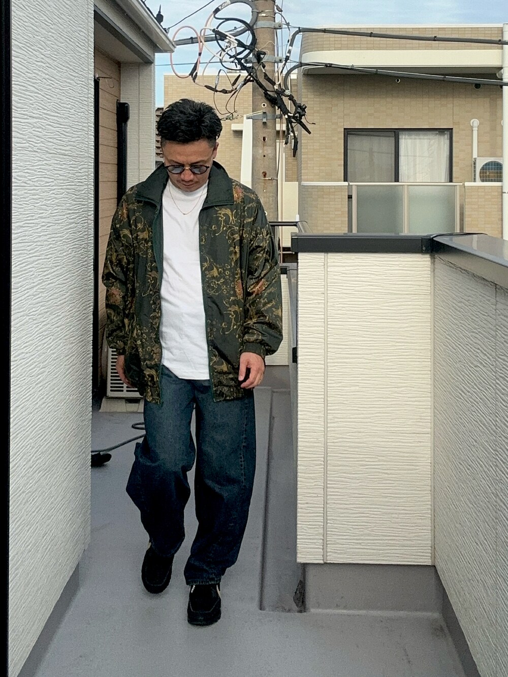 ホワイト系のTシャツ/カットソー、グリーン系のジャケット/アウター、ブルー系のデニムパンツを着用したメンズの秋コーディネートの2枚目の写真