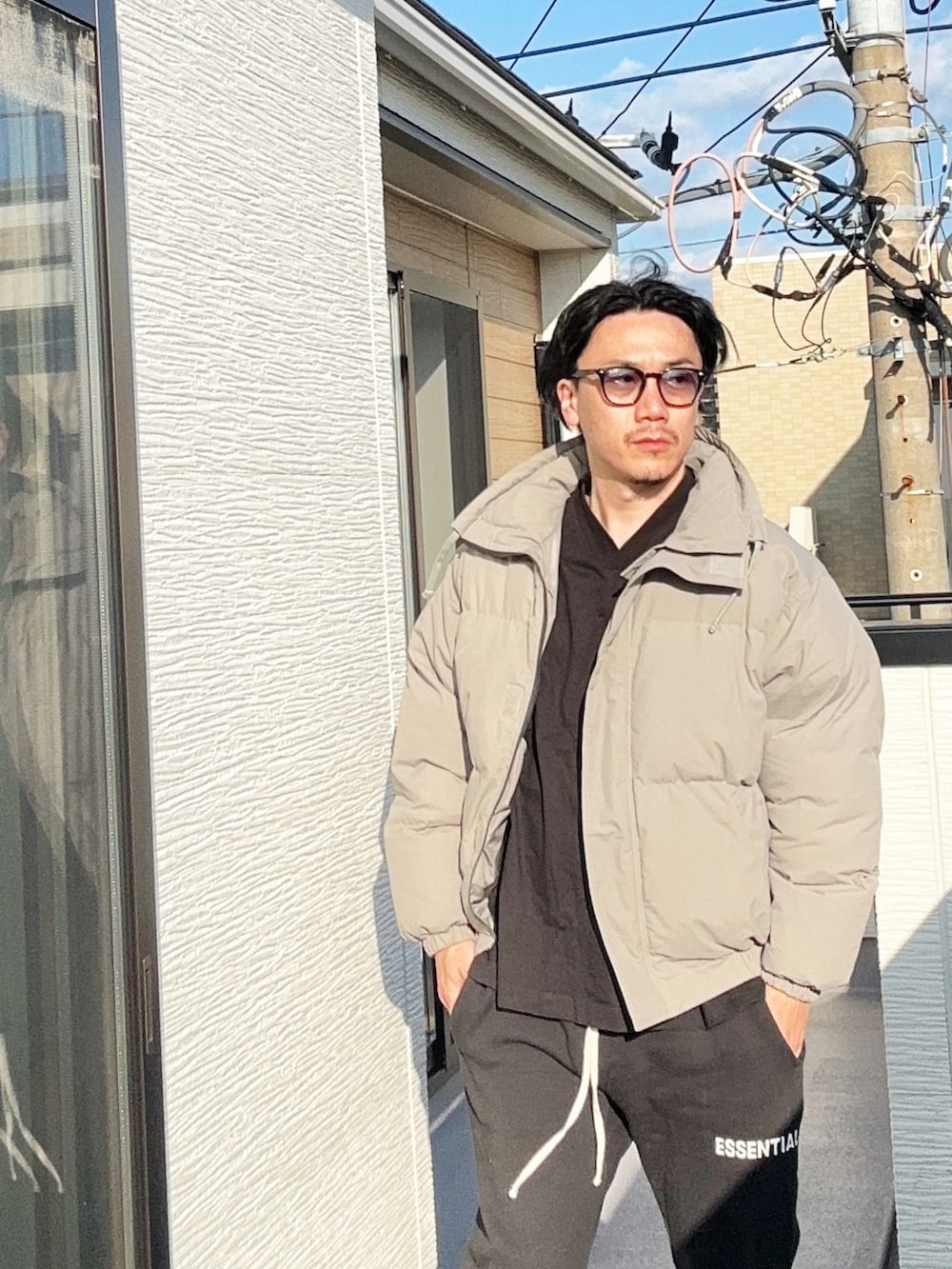 ブラック系のTシャツ/カットソー、グレー系のダウンジャケット/コート、ブラック系のスウェットパンツを着用したメンズの秋コーディネートの3枚目の写真