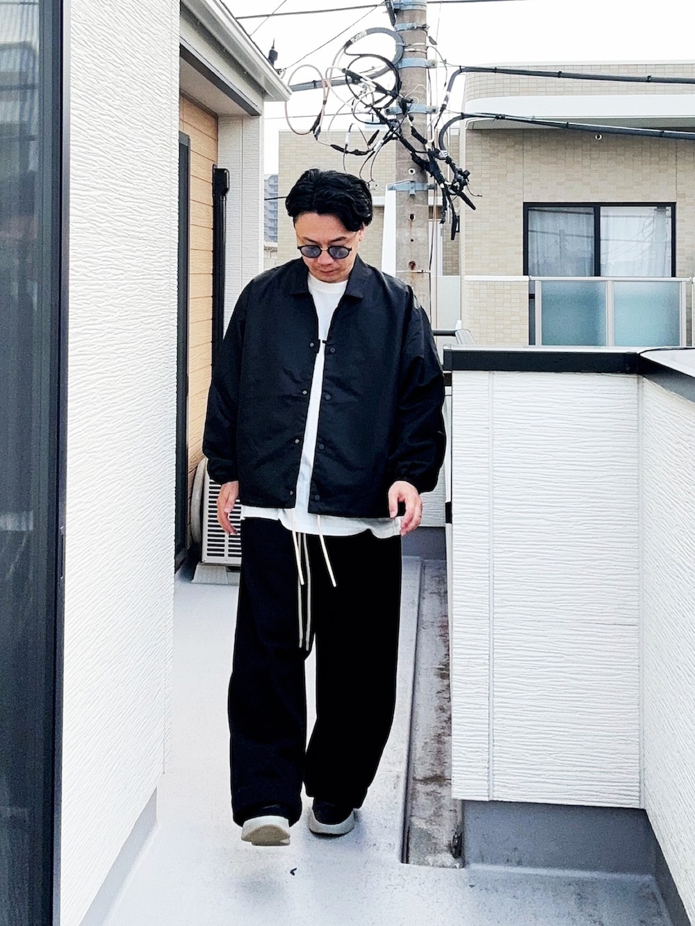 ブラック系のナイロンジャケット、ブラック系のスウェットパンツ、ホワイト系のTシャツ/カットソーを着用したメンズの秋コーディネートの4枚目の写真