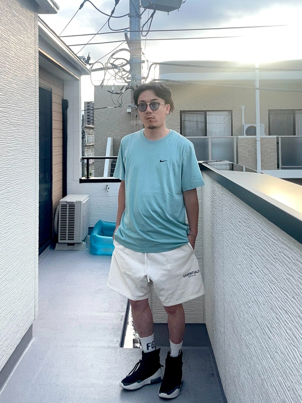 ブルー系のTシャツ/カットソー、ホワイト系のスウェットパンツ、ブラック系のスニーカーを着用したメンズの夏コーディネートの4枚目の写真