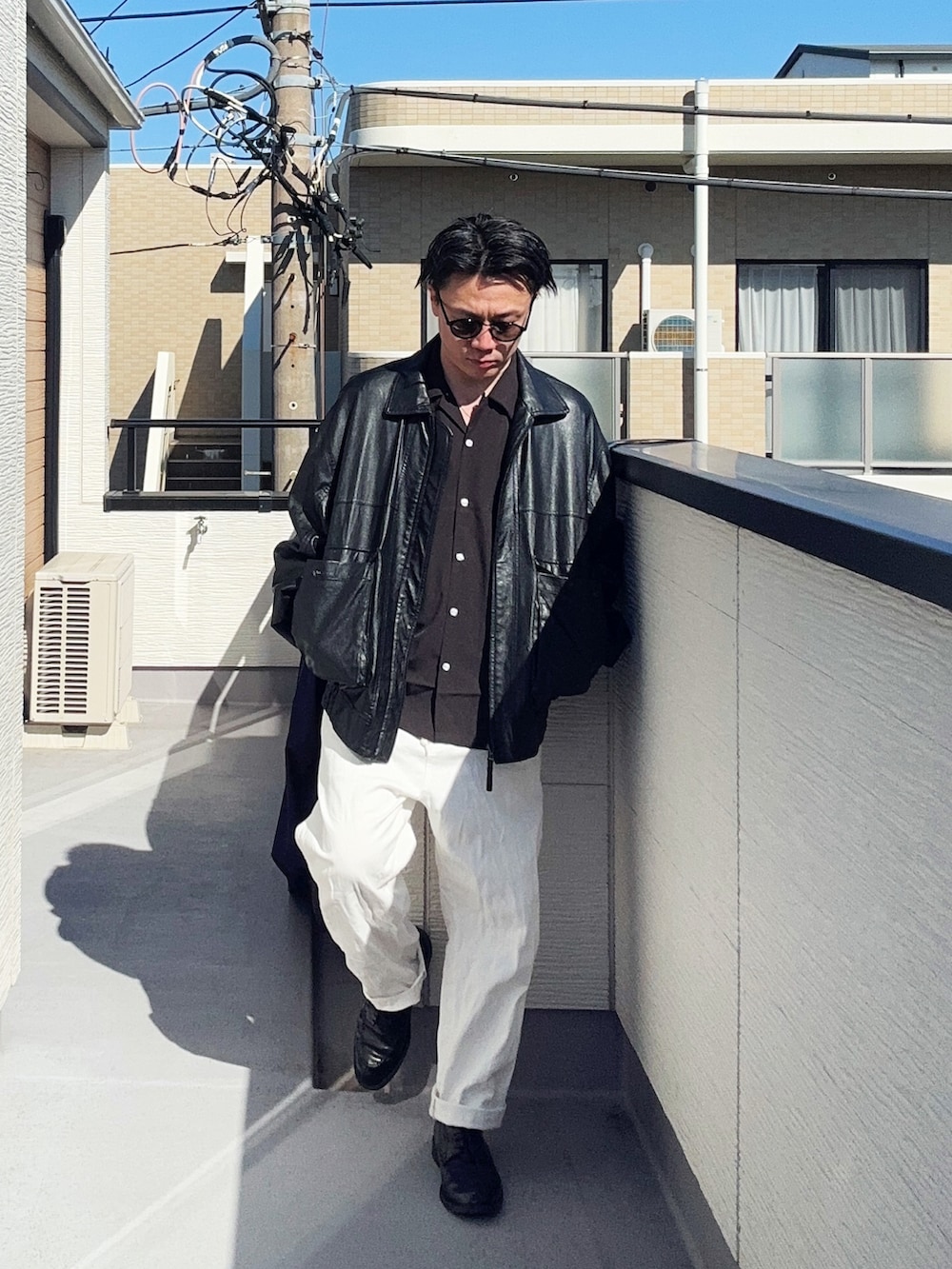 ブラック系のブルゾン、ホワイト系のデニムパンツ、ブラック系のシャツ/ブラウスを着用したメンズの春コーディネートの3枚目の写真