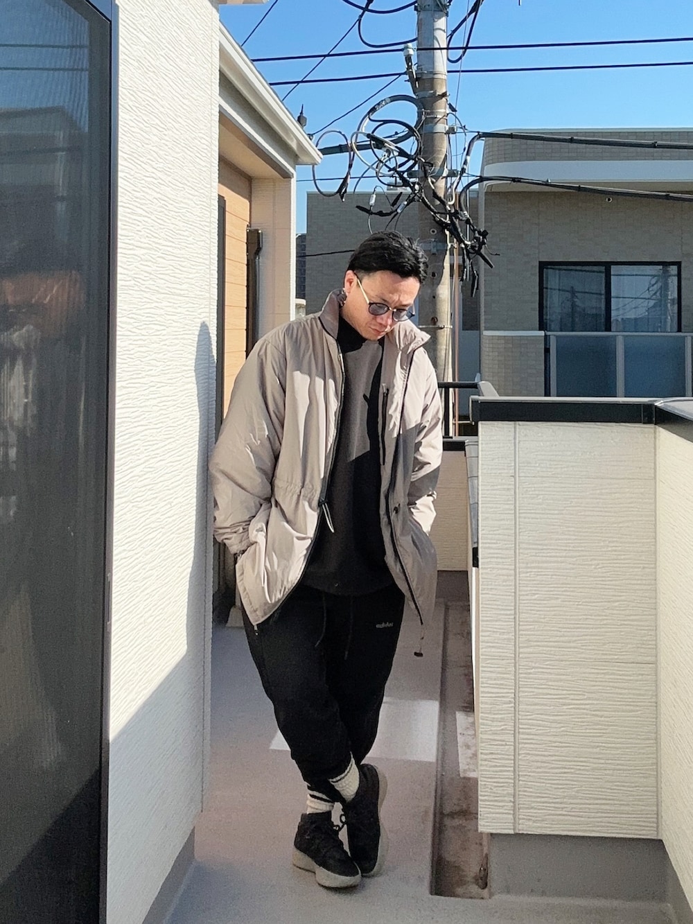 ブラック系のスニーカー、ブラック系のスウェットパンツ、ブラック系のスウェットを着用したメンズの冬コーディネートの3枚目の写真