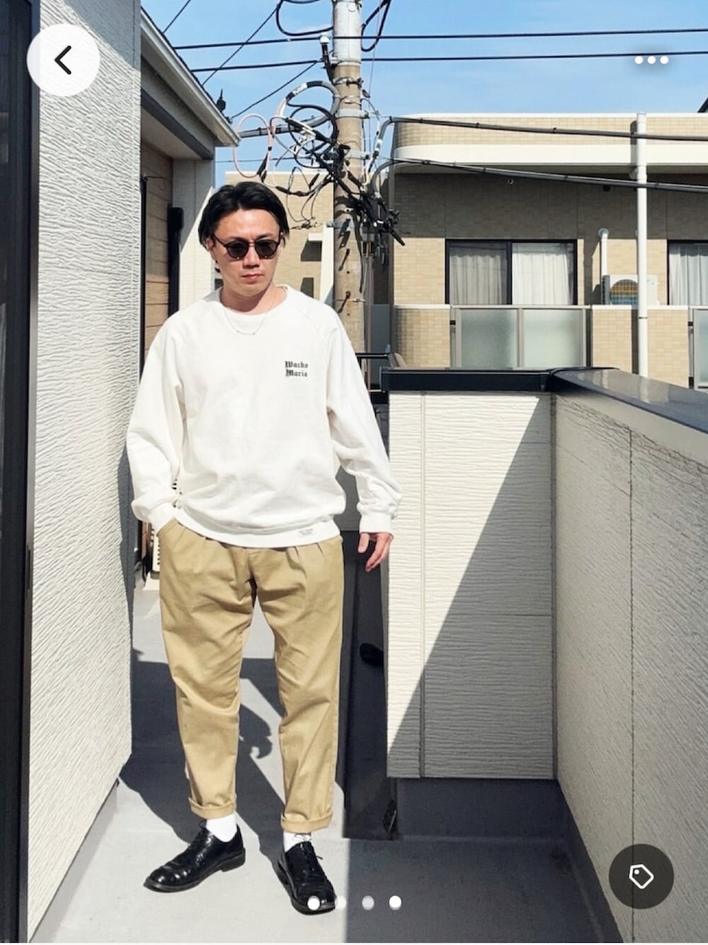 グリーン系のチノパンツ、ホワイト系のスウェット、ブラック系のドレスシューズを着用したメンズの春コーディネートの3枚目の写真