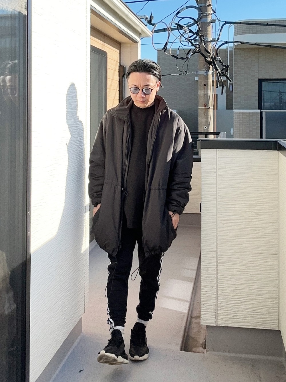 ブラック系のスウェット、ブラック系のスウェットパンツ、ブラック系のスニーカーを着用したメンズの冬コーディネートの4枚目の写真