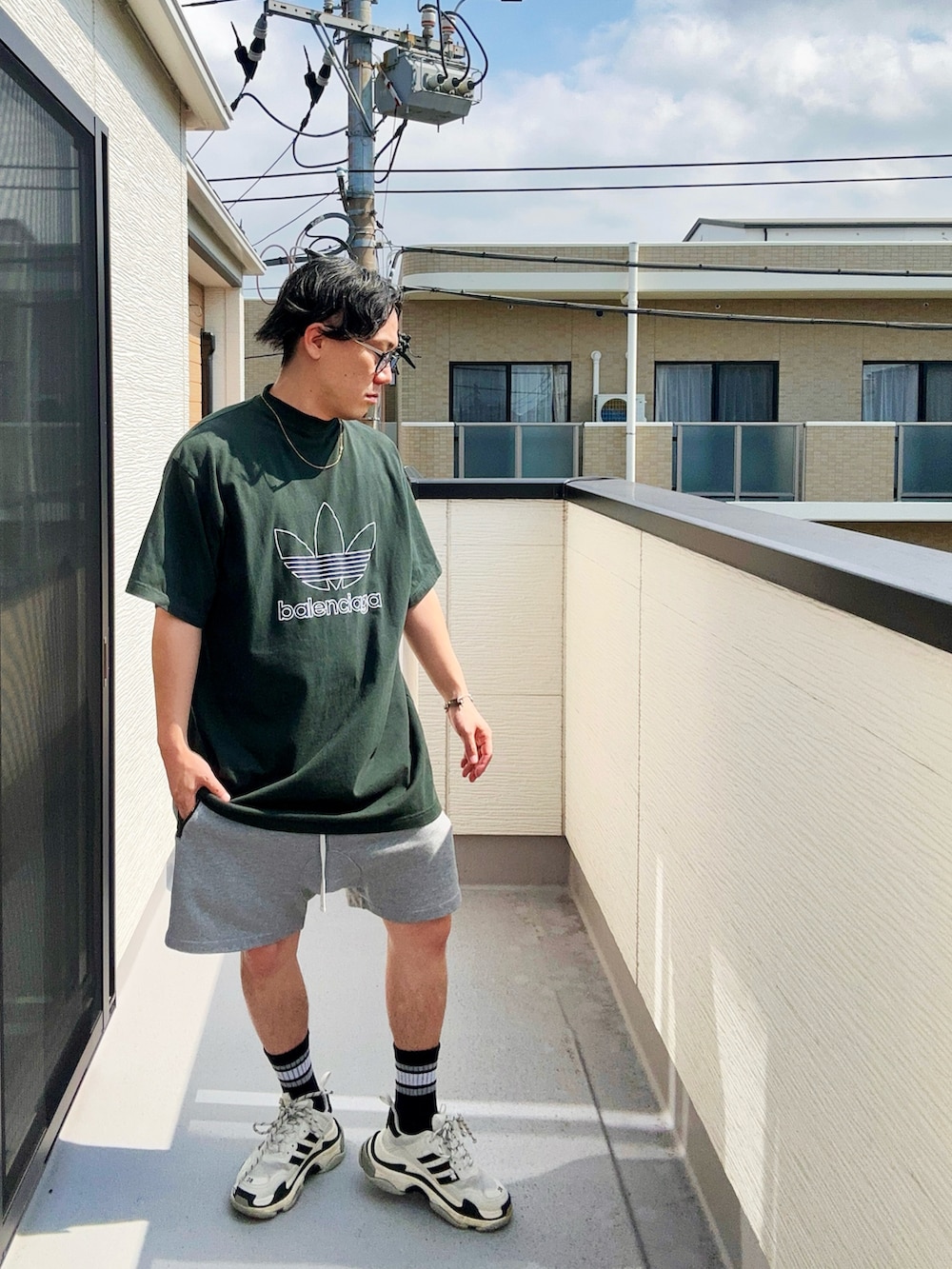 グリーン系のTシャツ/カットソー、グレー系のパンツ、ホワイト系のシューズを着用したメンズの秋コーディネートの2枚目の写真