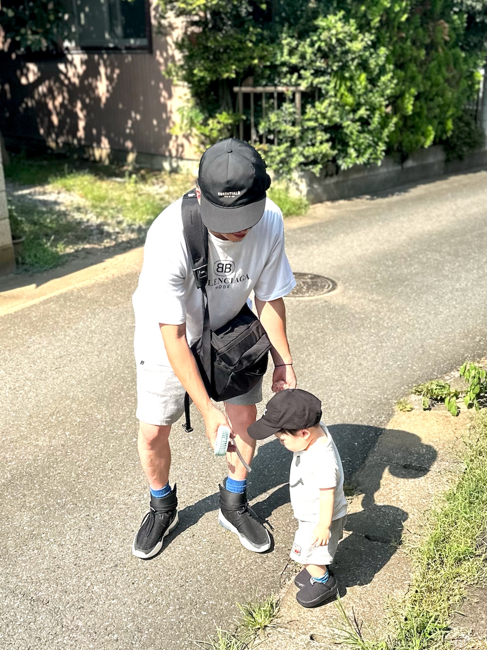 ブラック系のショルダーバッグ、ホワイト系のその他トップス、ホワイト系のTシャツ/カットソーを着用したメンズの夏コーディネートの4枚目の写真