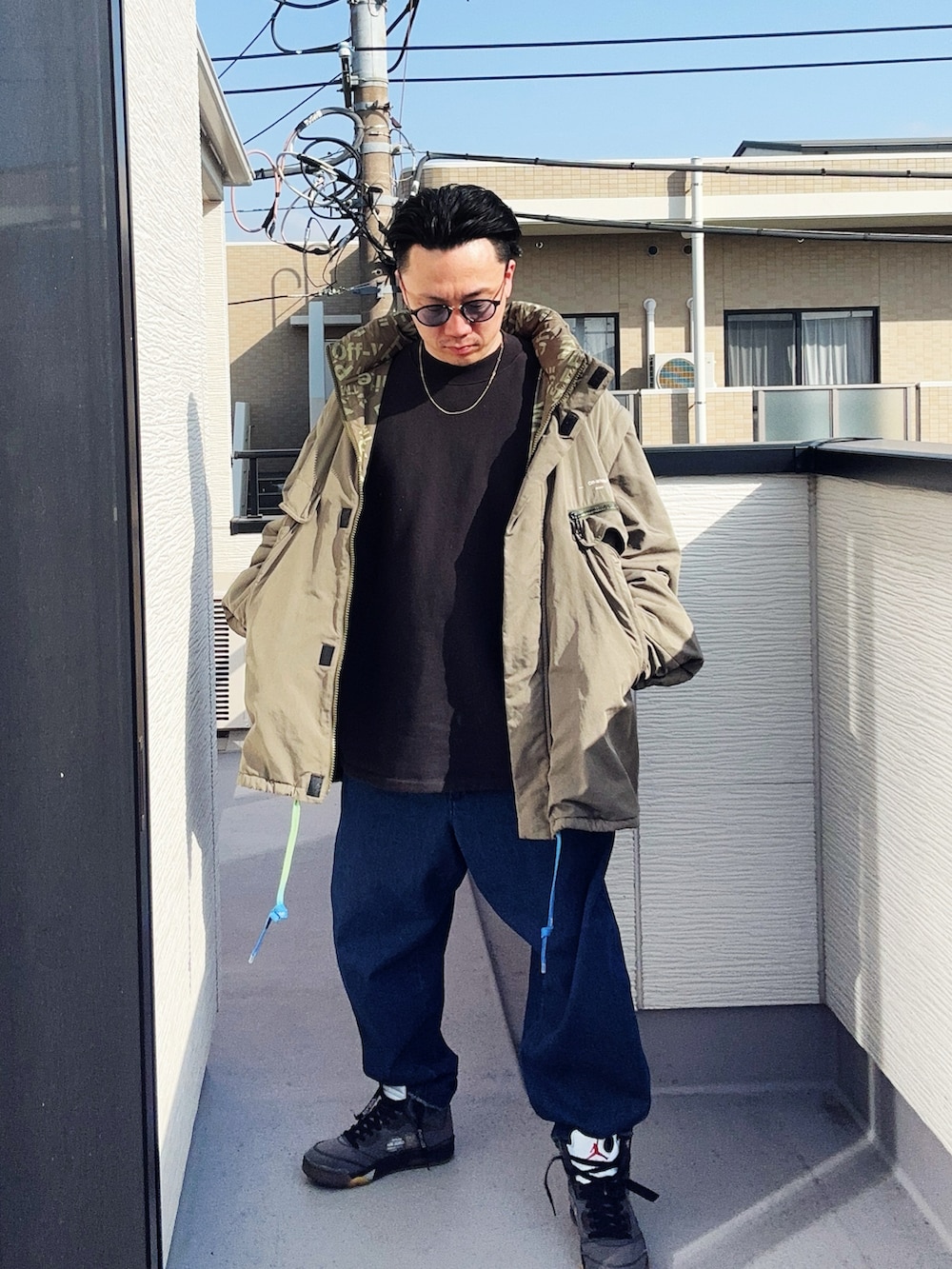 ブルー系のデニムパンツ、ブラック系のスウェット、グリーン系のミリタリージャケットを着用したメンズの冬コーディネートの3枚目の写真