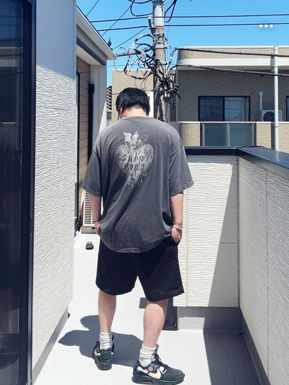 ブラック系のTシャツ/カットソー、ブラック系のパンツ、ブラック系のスニーカーを着用したメンズの夏コーディネートの4枚目の写真