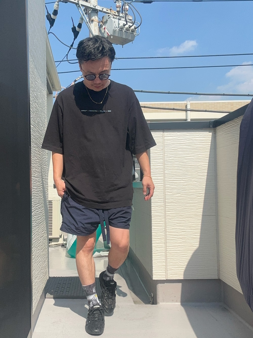 ブラック系のショルダーバッグ、ブラック系のTシャツ/カットソー、ブルー系のパンツを着用したメンズの夏コーディネートの4枚目の写真