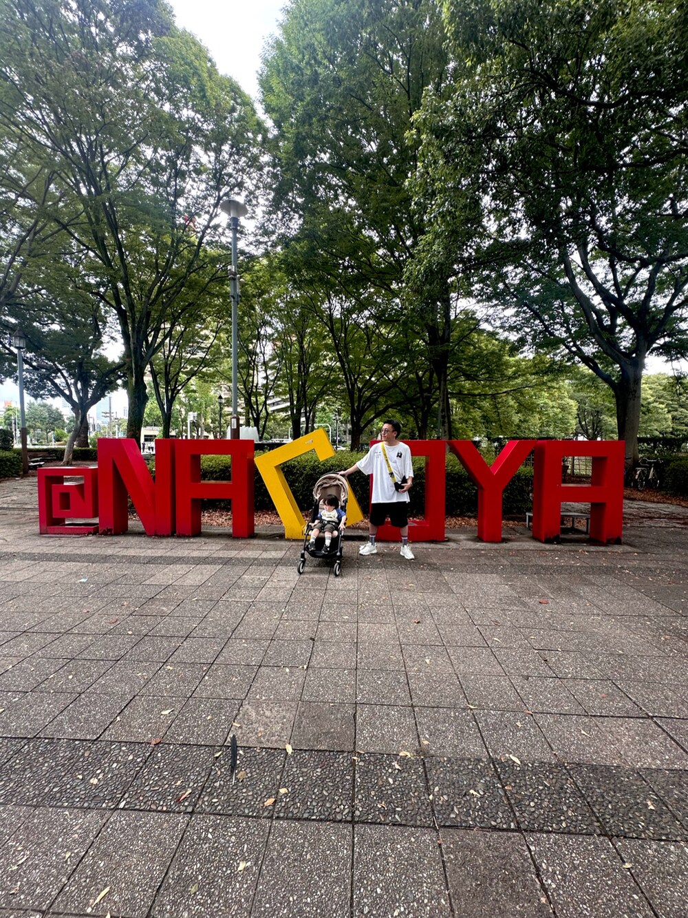 ブラック系のショルダーバッグ、ブラック系のスニーカー、ホワイト系のTシャツ/カットソーを着用したメンズの秋コーディネートの3枚目の写真