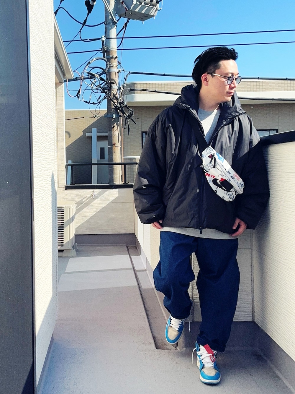 ブルー系のデニムパンツ、グレー系のスウェット、ブラック系のジャケット/アウターを着用したメンズの冬コーディネートの3枚目の写真