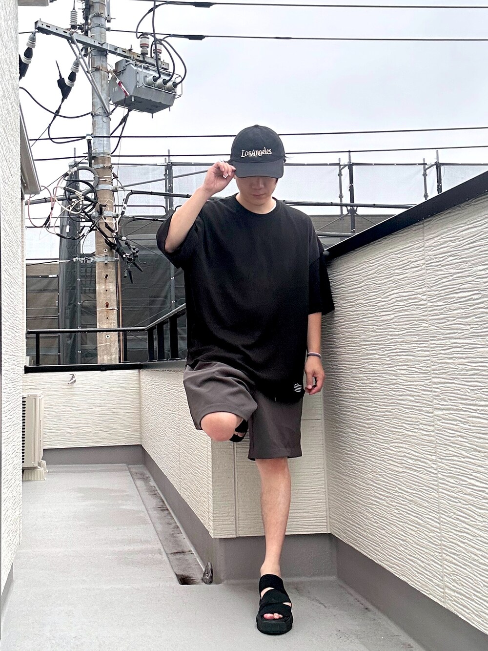 ブラック系のTシャツ/カットソー、グレー系のその他パンツ、ブラック系のサンダルを着用したメンズの夏コーディネートの2枚目の写真