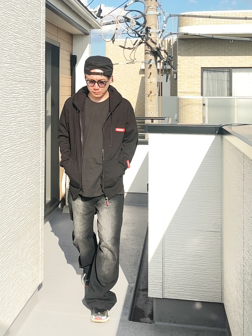 ブラック系のTシャツ/カットソー、ブラック系のパーカー、ブラック系のデニムパンツを着用したメンズの秋コーディネートの2枚目の写真