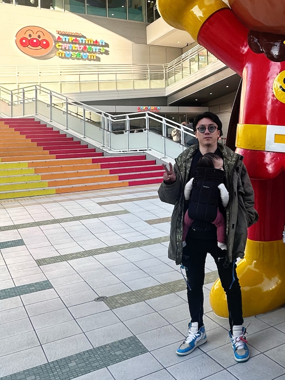 ブルー系のスウェット、ベージュ系のTシャツ/カットソー、グリーン系のミリタリージャケットを着用したメンズの冬コーディネートの3枚目の写真