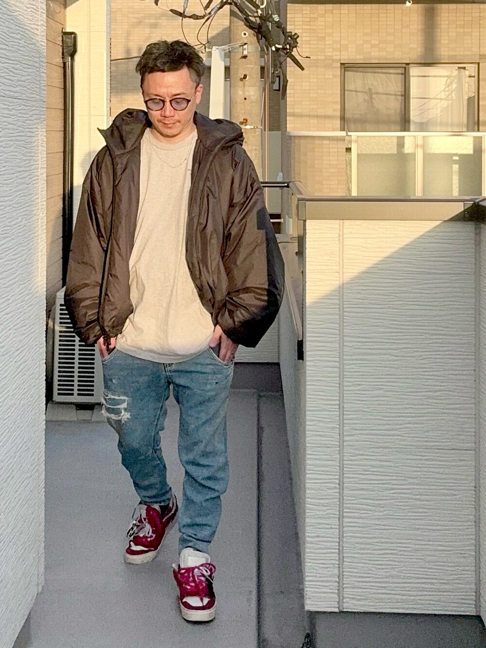 グレー系のTシャツ/カットソー、ブルー系のデニムパンツ、ブラック系のジャケット/アウターを着用したメンズの秋コーディネートの2枚目の写真