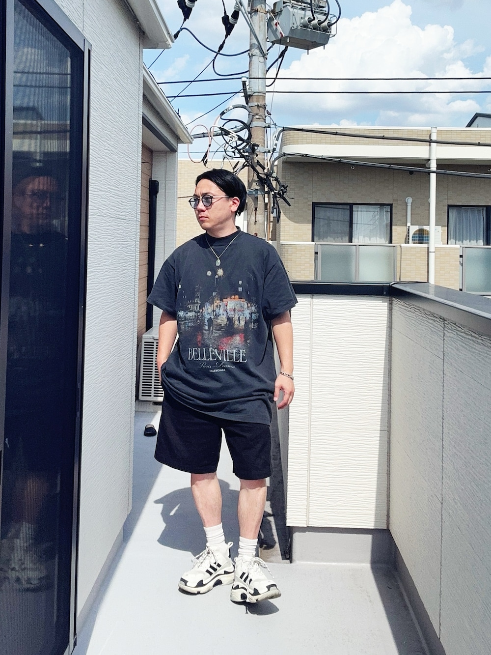 ブラック系のTシャツ/カットソー、ブラック系のパンツ、ホワイト系のシューズを着用したメンズの夏コーディネートの2枚目の写真